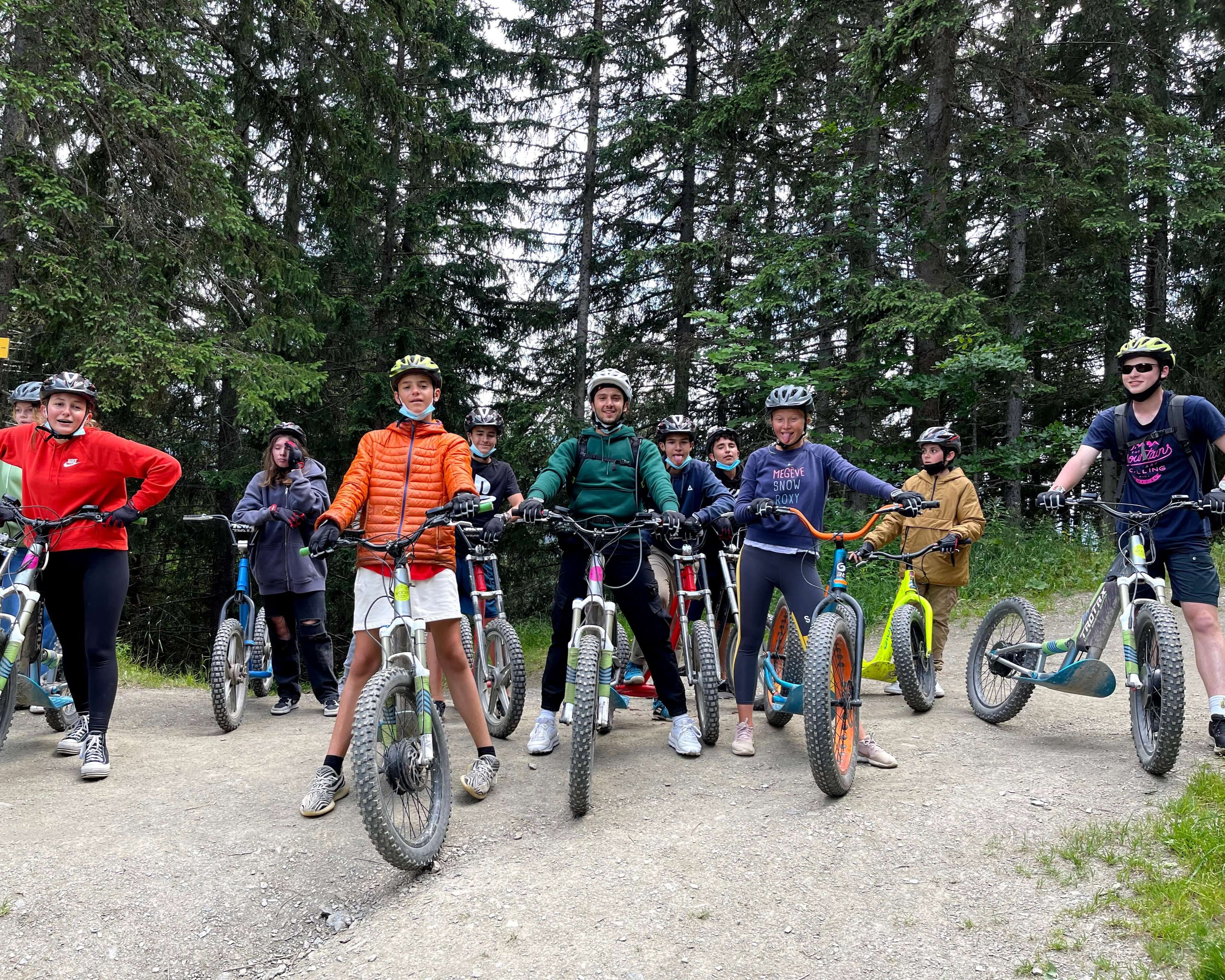 Teen campers enjoying a biking adventure in the scenic Megève Alps during summer programs.