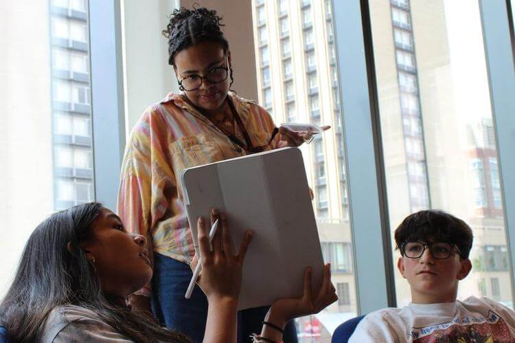 Facilitator guiding high school students in a collaborative summer program session at Futures Forge.