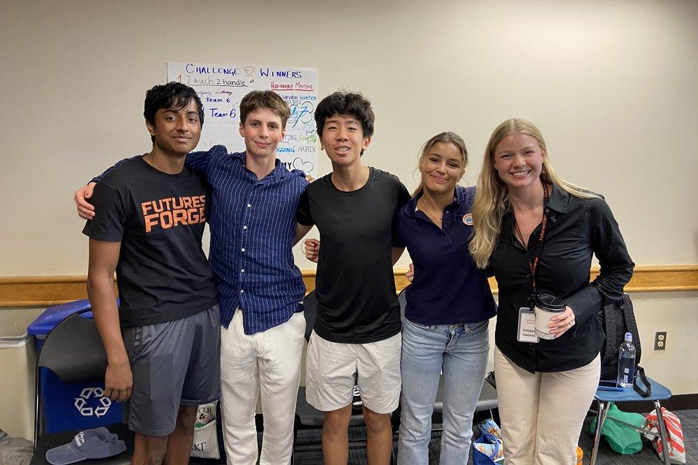 Five high school students celebrating teamwork in a summer program focused on skills for success in college and careers.