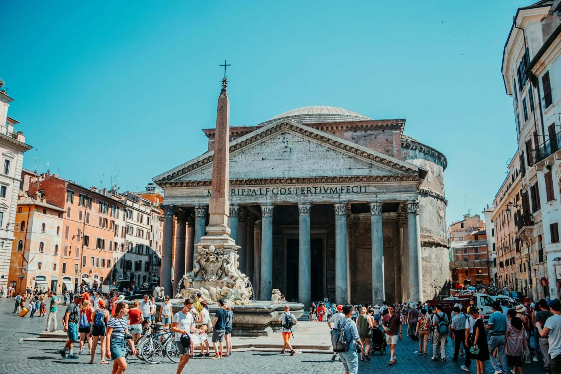 Panoramic view of the Pantheon in Rome with tourists and vibrant buildings surrounding it.