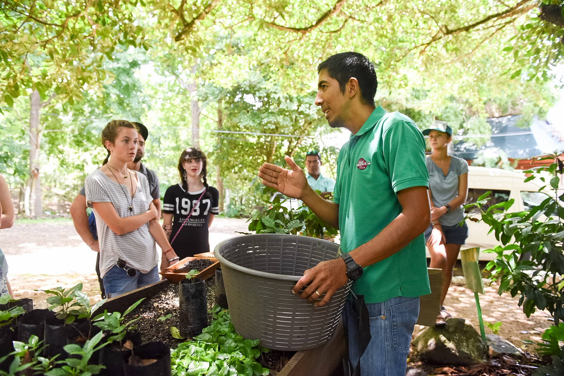 A conservationist explains sea turtle protection to teens at a summer program in Costa Rica, surrounded by green nature.