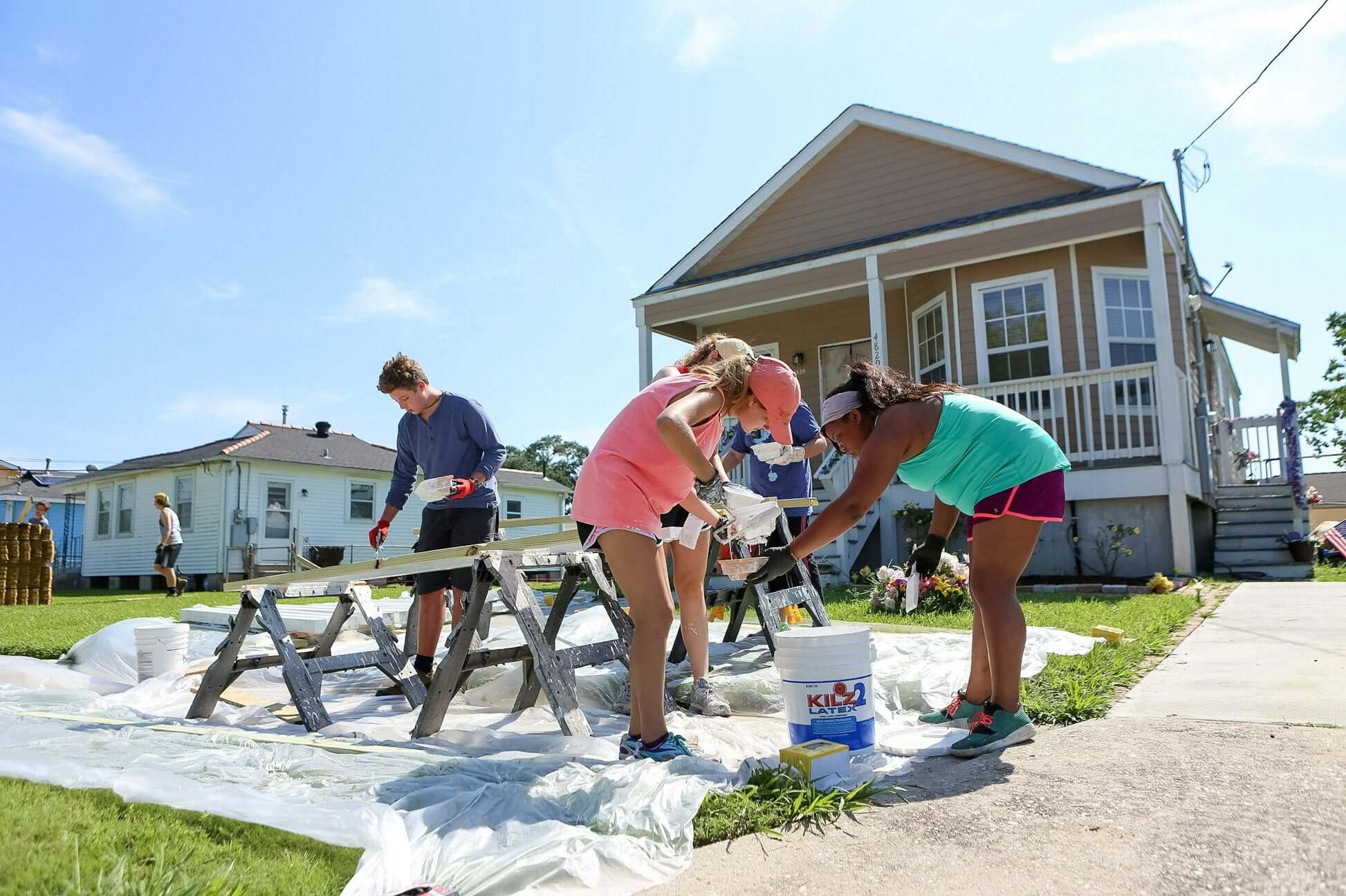 High school students volunteering to rebuild homes in New Orleans during a summer program.