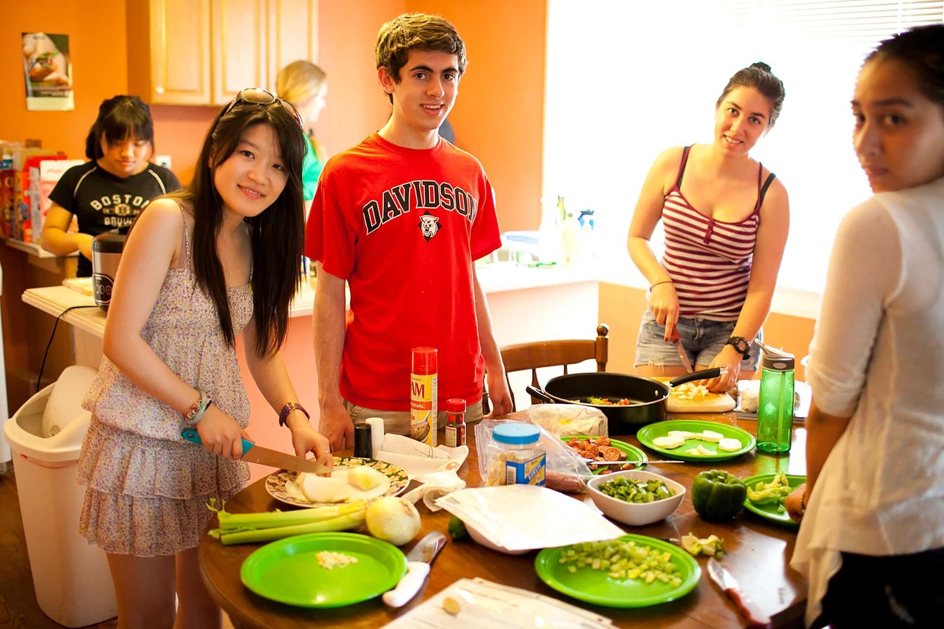 High school students preparing ingredients in a kitchen for a group cooking activity during a summer program in New Orleans.