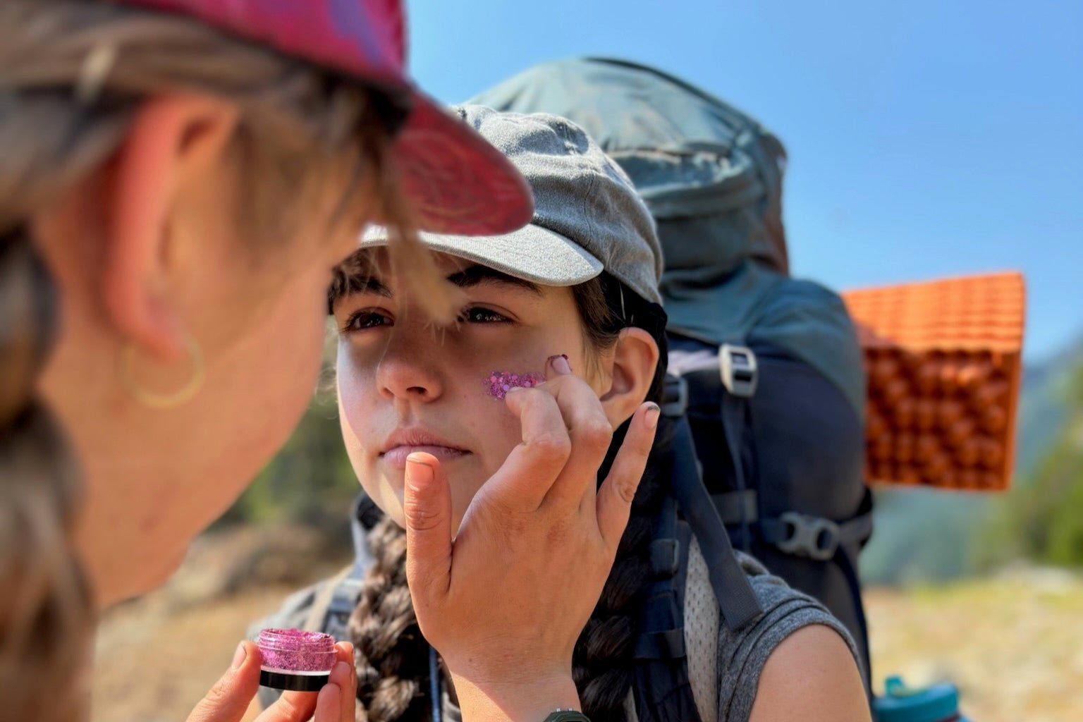 Campers applying sunscreen during an outdoor summer adventure at Alpengirl Camp.