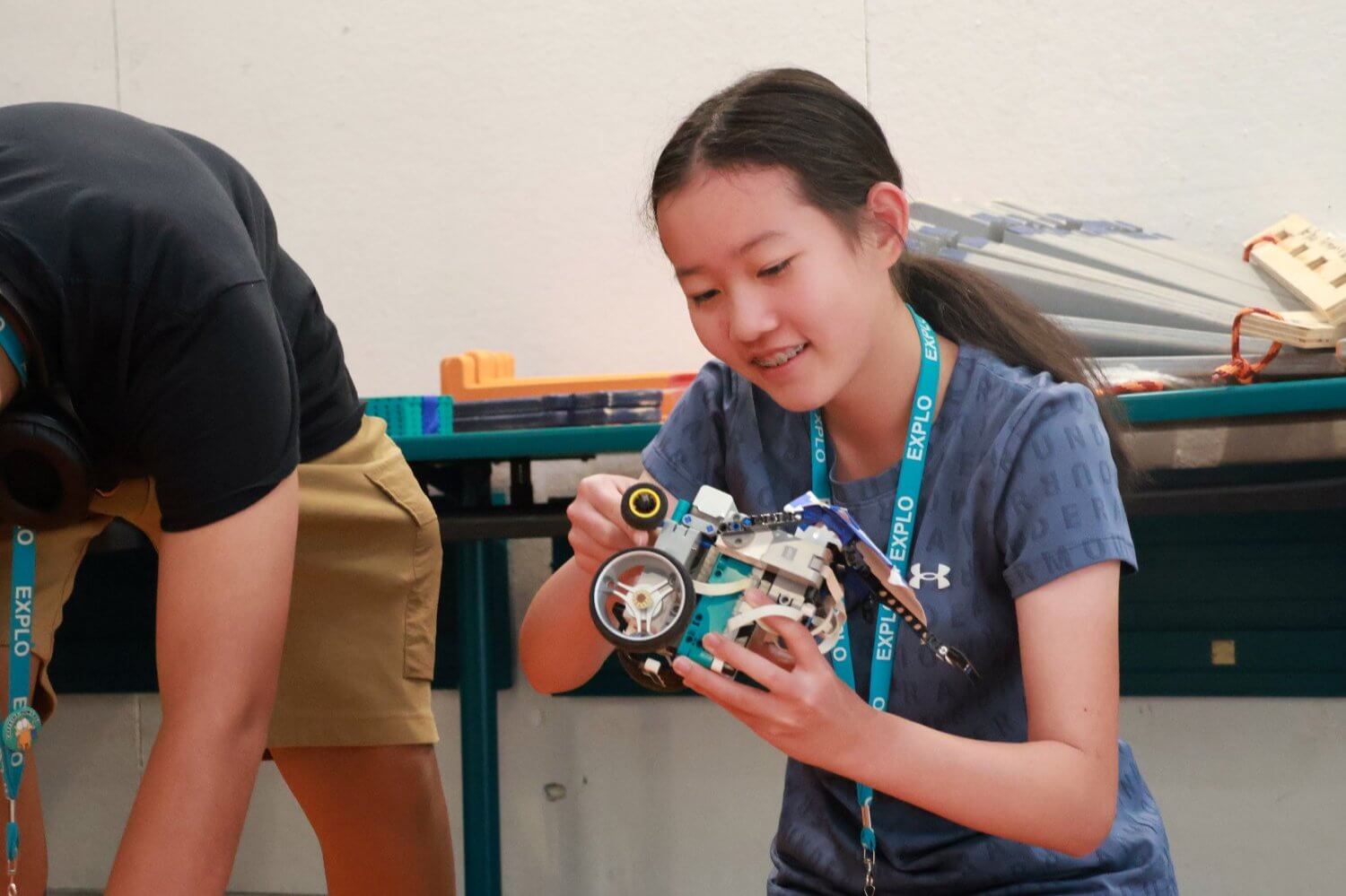 Middle school student engaged in a summer program, building a robotics project at EXPLO camp.